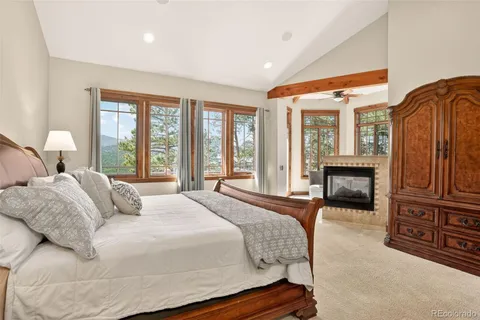 a bedroom with a large bed and a fireplace