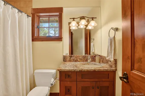 a bathroom with a granite countertop sink toilet a mirror and a shower