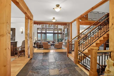 a living room with furniture stairs and a large window