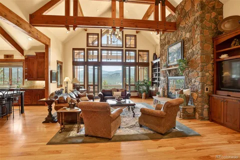 a living room with fireplace furniture and a large window