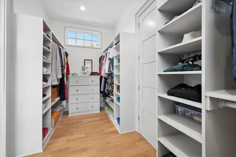 a view of walk in closet with clothes and shoes