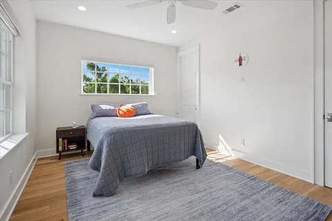 a bedroom with a bed and wooden floor
