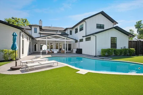 a view of a house with a yard patio and swimming pool