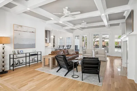 a living room with furniture a wooden floor and a chandelier