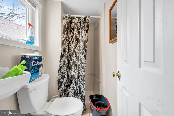a white toilet sitting next to a shower curtain