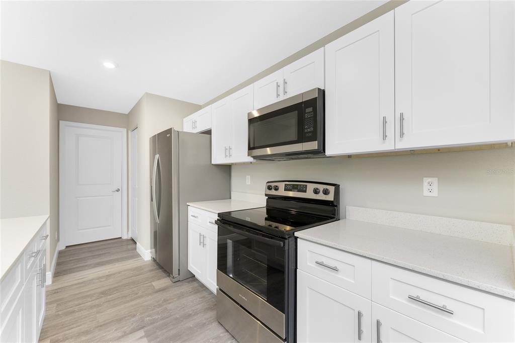 6397 Filbert Street North Port, FL 34288 - Photo 11 of 71 a kitchen with stainless steel appliances a stove microwave and refrigerator