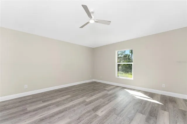 a view of an empty room with wooden floor and closet