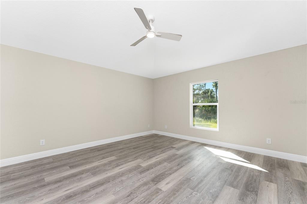 6397 Filbert Street North Port, FL 34288 - Photo 26 of 71 an empty room with wooden floor fan and windows