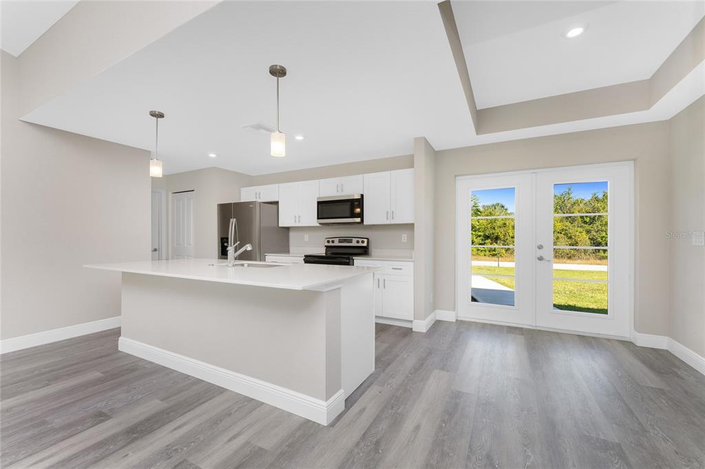 6397 Filbert Street North Port, FL 34288 - Photo 5 of 71 a view of kitchen with stainless steel appliances granite countertop a stove top oven a sink dishwasher and a fireplace with wooden floor