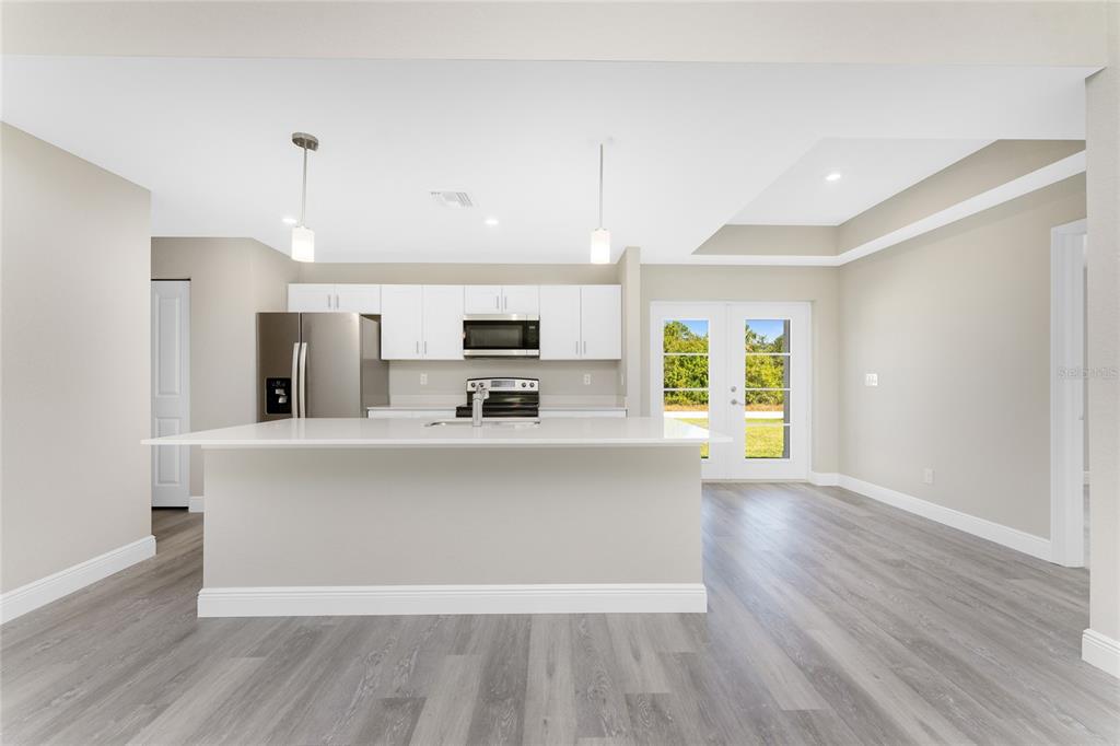 6397 Filbert Street North Port, FL 34288 - Photo 6 of 71 a view of kitchen with stainless steel appliances a stove top oven a sink dishwasher a refrigerator and a dining table with wooden floor