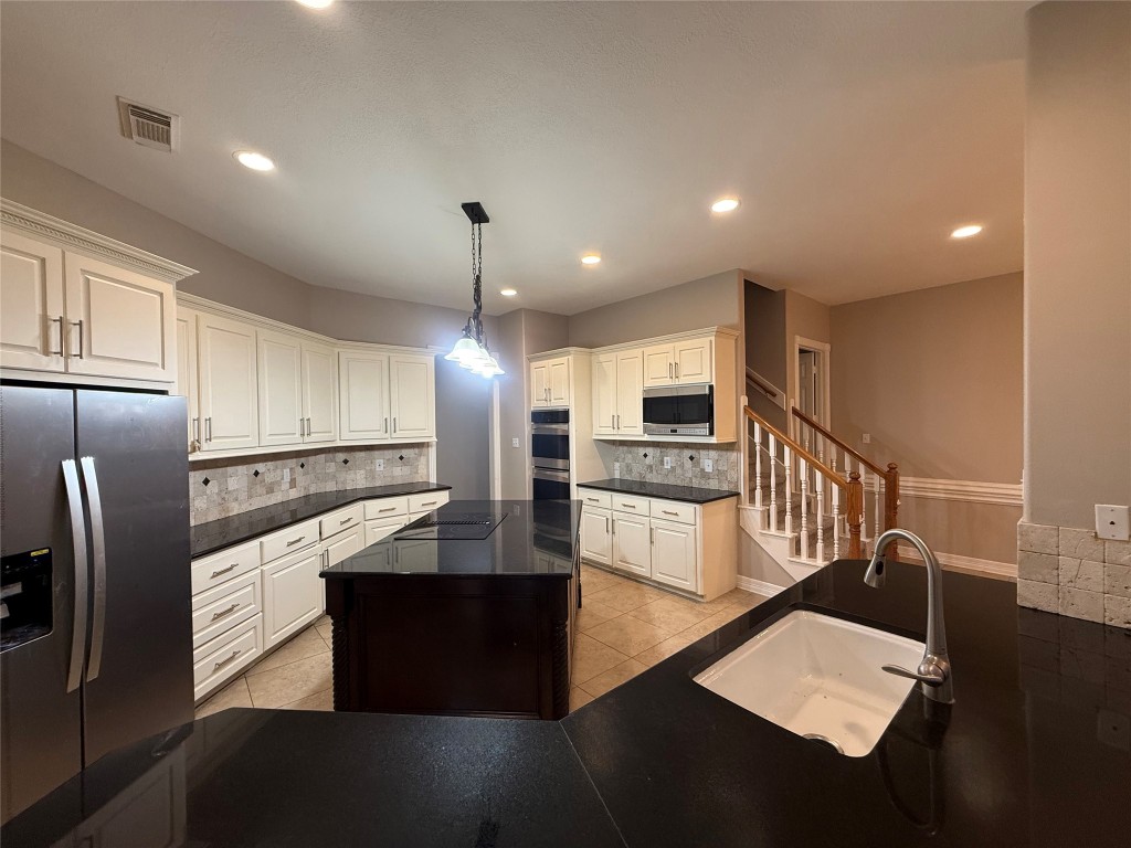 13523 Pegasus Road Cypress, TX 77429 - Photo 13 of 36 a kitchen with granite countertop a refrigerator a sink and wooden floor