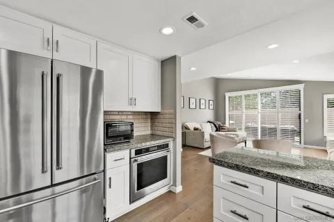a kitchen with granite countertop a refrigerator stove and sink