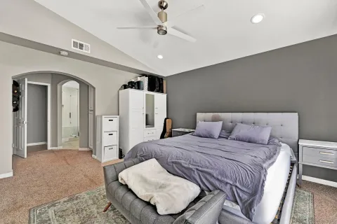 a bedroom with a large bed a chandelier and closet