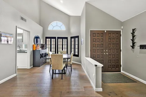 a dining room with furniture entryway and wooden floor