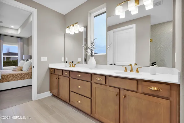 a bathroom with double vanity and a mirror