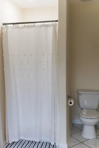 a bathroom with a toilet and a shower curtain