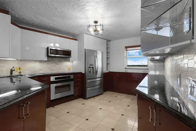 a kitchen with kitchen island granite countertop a sink stove and refrigerator