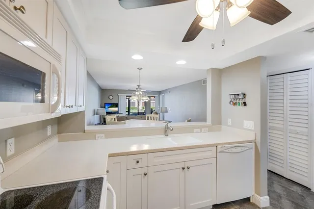 a kitchen with a sink dishwasher and a stove with wooden floor
