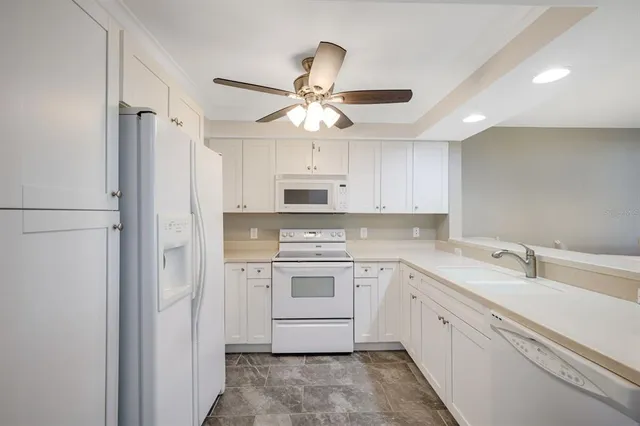 a kitchen with white cabinets and white appliances