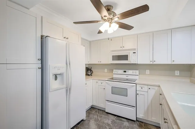 a kitchen with cabinets stainless steel appliances and a window