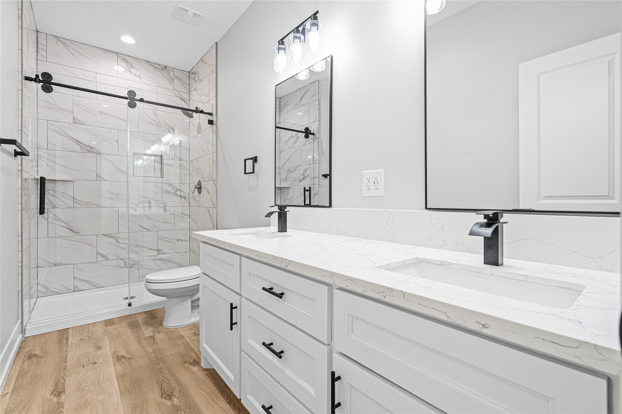 3821 Easy Street, Unit A Houston, TX 77026 - Photo 7 of 10 a bathroom with a double vanity sink toilet mirror and shower