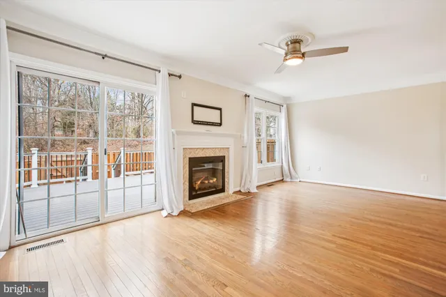 wooden floor fireplace and windows in an empty room