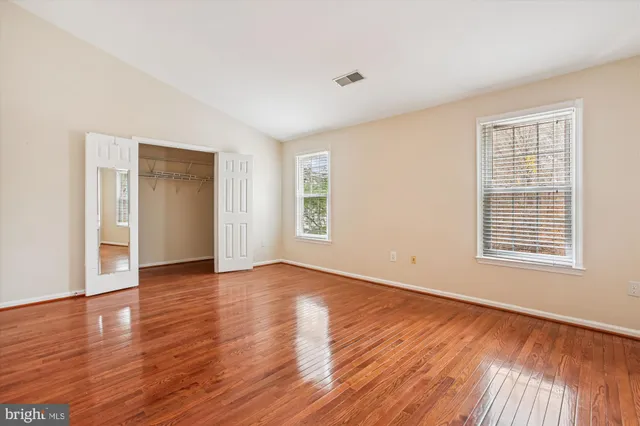 a view of an empty room with wooden floor