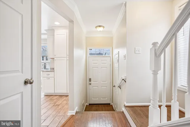 a view of a hallway with wooden floor and staircase
