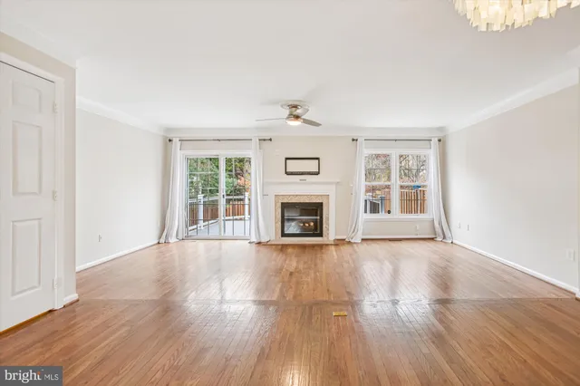 wooden floor fireplace and windows in an empty room