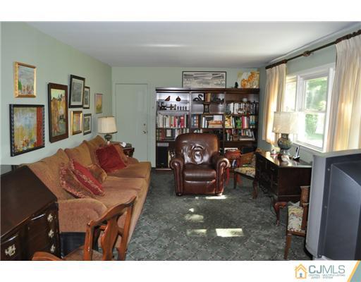 9 Agate Road East Brunswick, NJ 08816 - Photo 7 of 19 a living room with furniture a rug and a bookshelf