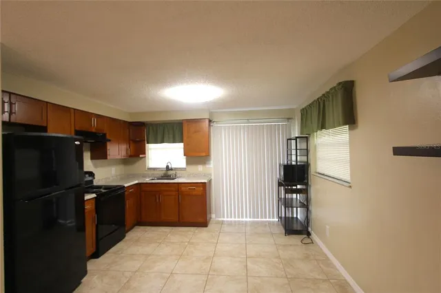 a kitchen with granite countertop a refrigerator and a sink