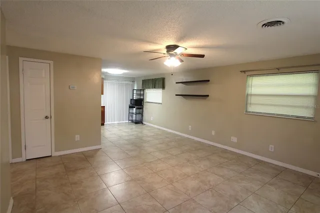a view of a livingroom with a chandelier fan and windows
