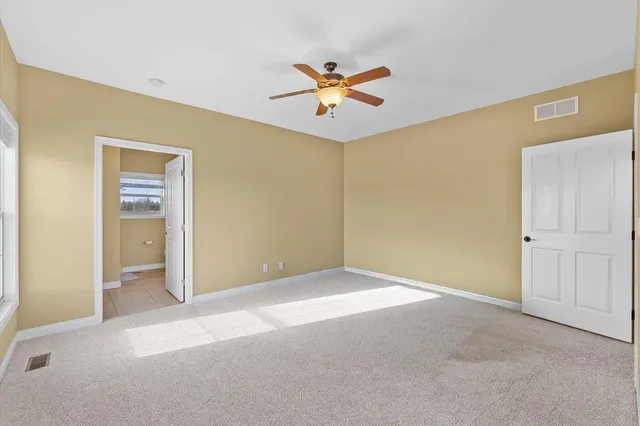 a view of an empty room and a ceiling fan