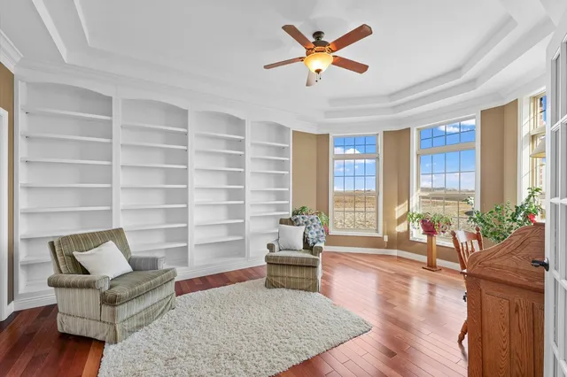 a view of an empty room with chandelier fan and a window