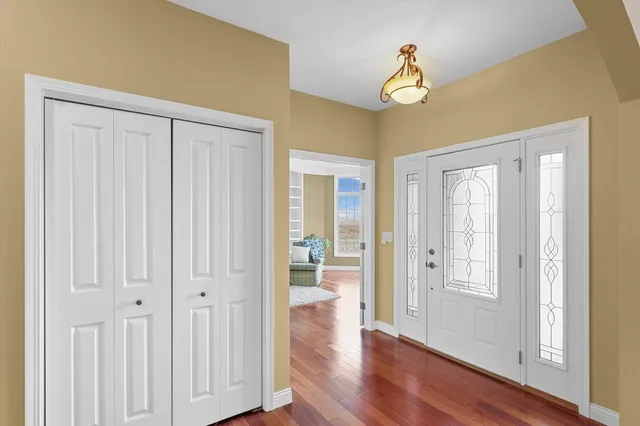 a view of a hallway with wooden floor and cabinet doors