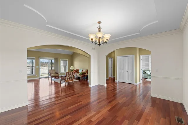 a view of a room with wooden floor and a chandelier