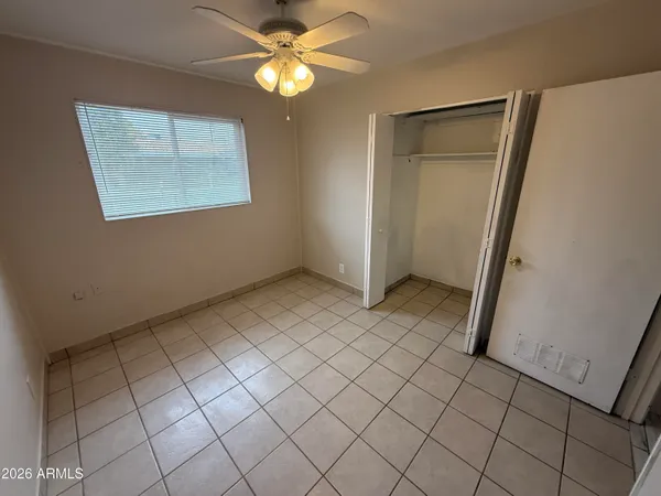 an empty room with windows and fan