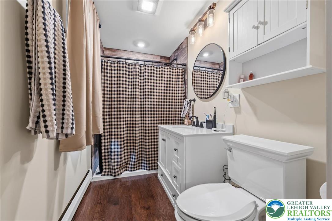 3771 State Road Coopersburg, PA 18036 - Photo 23 of 37 Rich wood flooring pairs elegantly with a clean white vanity in this updated bathroom.
