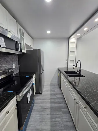 a kitchen with stainless steel appliances granite countertop a sink and a stove