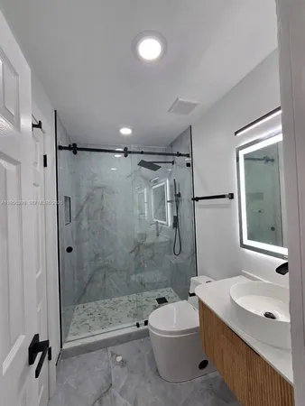 a bathroom with a sink toilet a mirror and shower