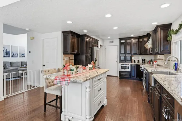a kitchen that has a lot of cabinets a sink and wooden floor