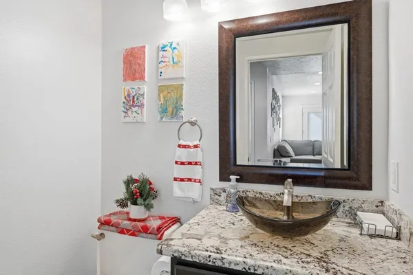 a bathroom with a granite countertop sink and a mirror