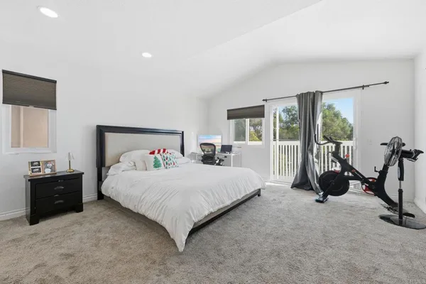 a bedroom with a bed and a flat tv screen on dresser