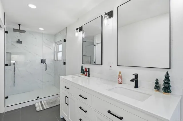a bathroom with a double vanity sink mirror double and shower