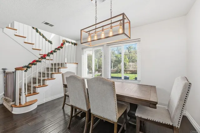 a dining room with wooden floor and windows