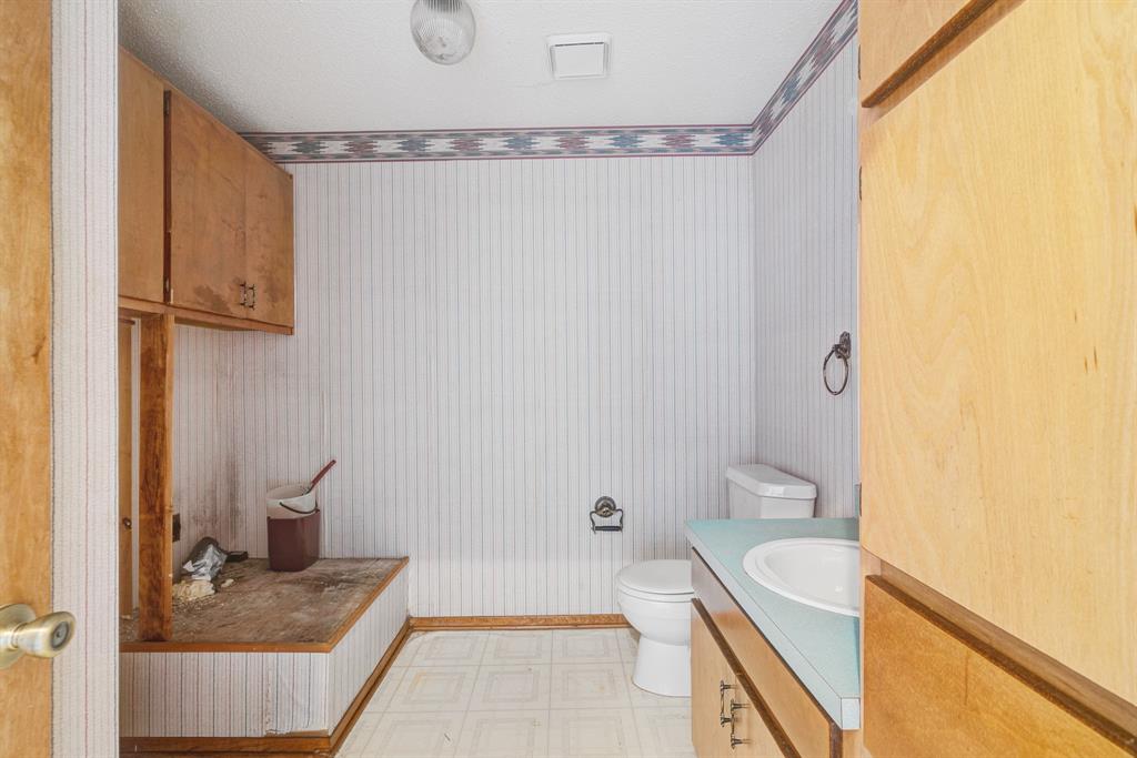 109 Private Road Brookston, TX 75421 - Photo 23 of 26 a bathroom with a granite countertop sink a toilet and shower