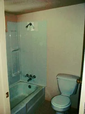 a bathroom with a granite countertop toilet a sink and shower