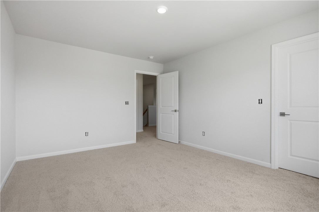 552 Hydrangea Street, Unit LOT 66 Seneca, SC 29678 - Photo 27 of 31 A well-lit room awaits personalization, featuring soft carpeting and a simple, inviting layout.