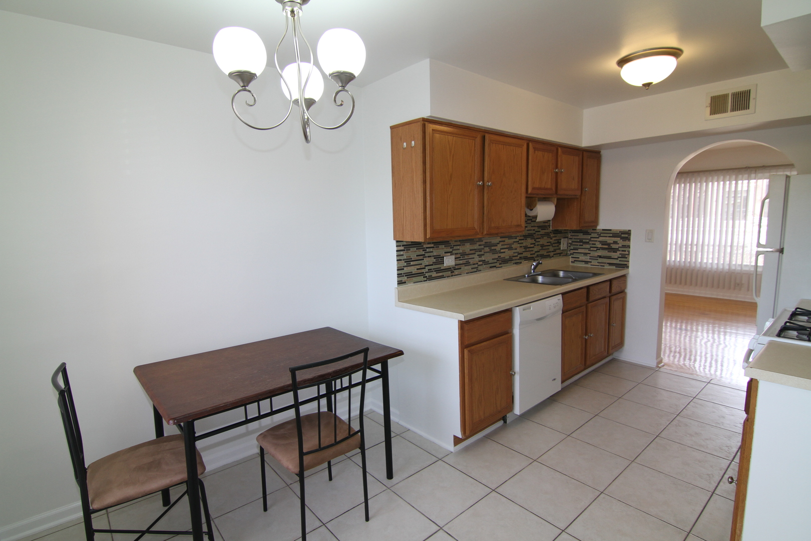 4909 North Harlem Avenue, Unit 1 Chicago, IL 60656 - Photo 4 of 8 a kitchen with a table chairs and a chandelier