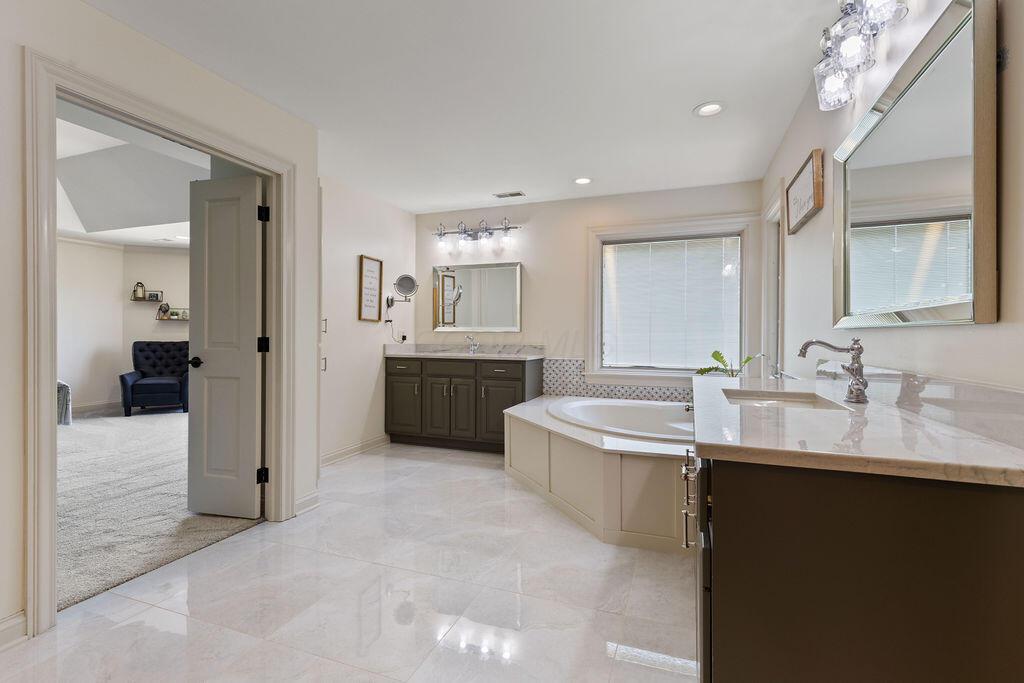 2570 Jewett Road Powell, OH 43065 - Photo 52 of 104 • Porcelain tile flooring • Ivory painted walls • Garden tub with cultured marble surround • Linen cabinet • His & hers vanity with single bowl, granite sinktops • (2) 4 bulb wall lights • Shower stall with glass doors & ceramic tile surround